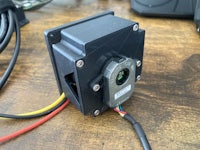 a small camera attached to a wooden table